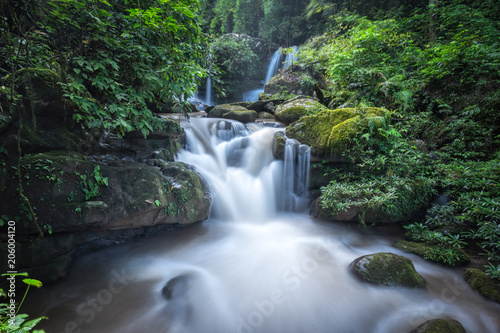 Waterfall in Thailand. Peaceful natural background with beautiful waterfall in jungle rainforest with wet stones in water and natural pond pool.