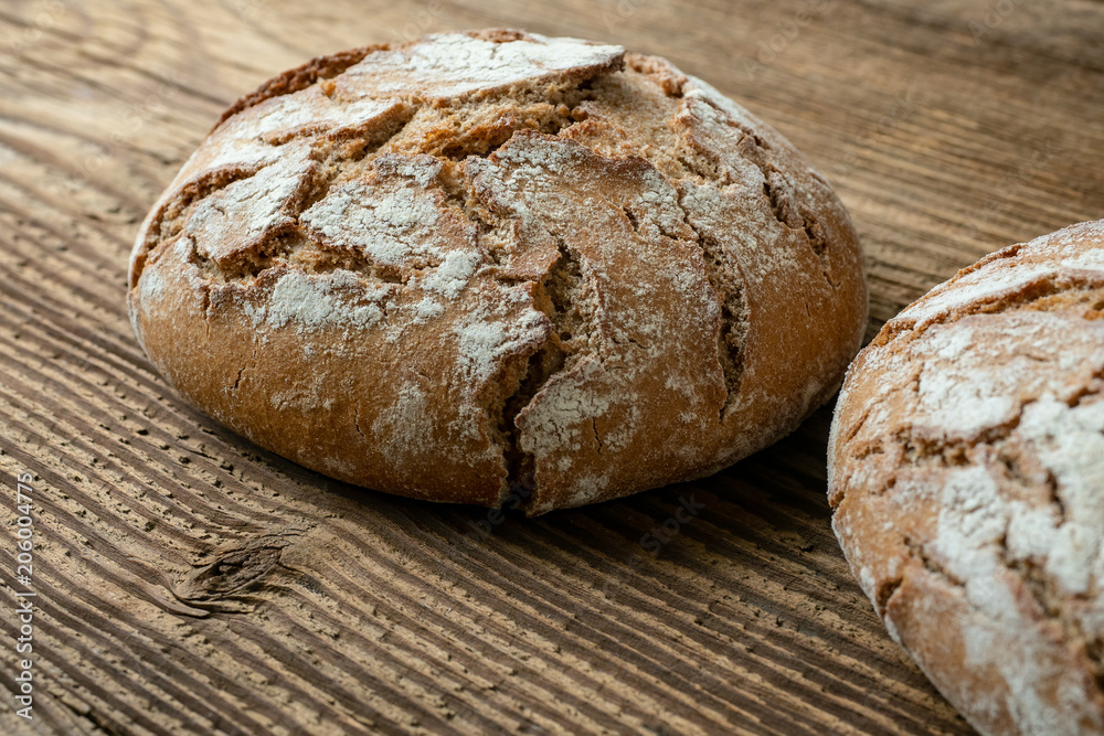 Delicious baked bread on a wooden background