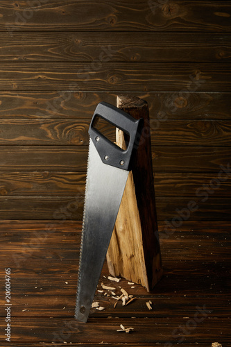 Φωτογραφία closeup view of handsaw and log on wooden brown table