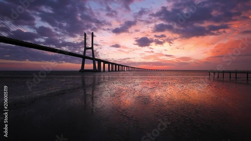 Timelapse of cloudy sunrise over the Vasco da Gama Bridge. Lisbon, Portugal