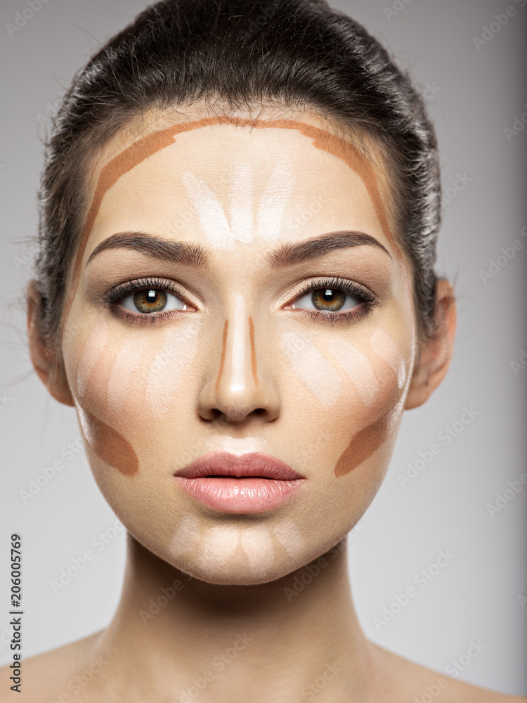 Cosmetic makeup tonal foundation is on woman's face. Cosmetic makeup tonal foundation is on woman's face.