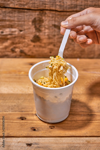 instant noodle, asian fast food, noodle cup on wooden background.