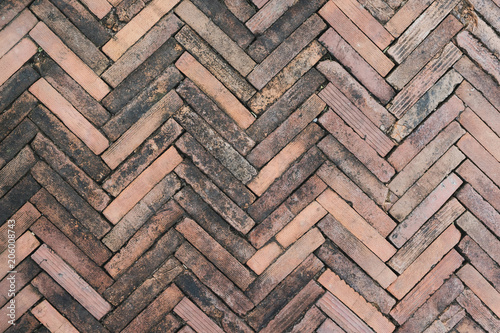 background of grunge red brick floor, arrow shaped pattern of old bricks on ground for decoration