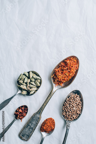 top view of group of spices in spoons on white table
