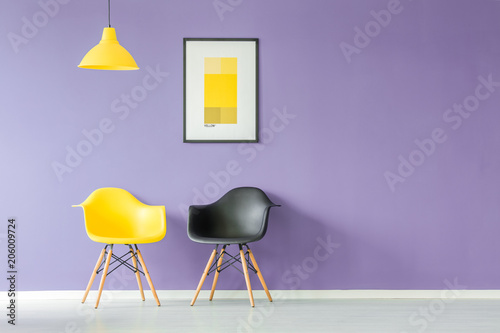 Contrasting color chairs against wall