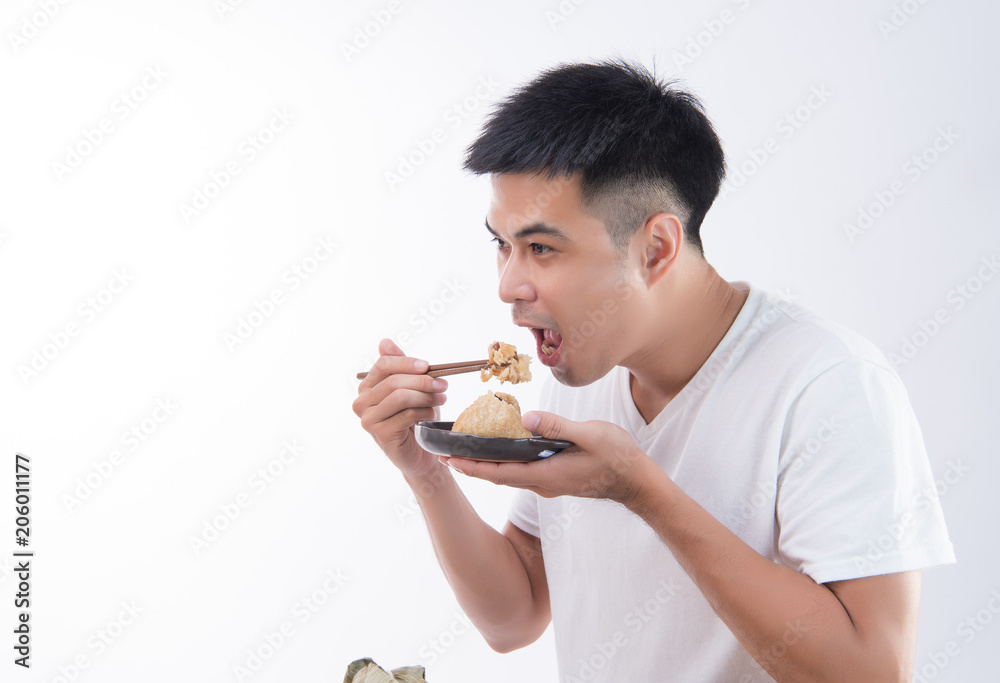 A man is going to eat delicious zongzi(rice dumpling) on Dragon Boat Festival, Asian traditional food, white background A man is going to eat delicious zongzi(rice dumpling) on Dragon Boat Festival, Asian traditional food, white background