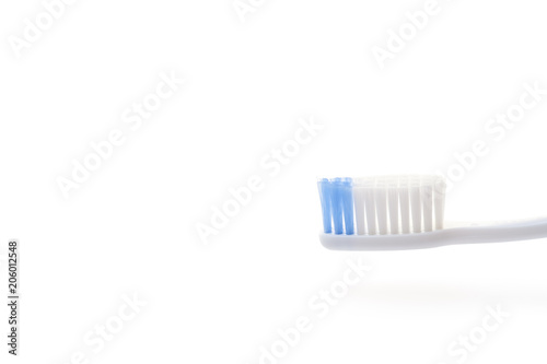 Close-up white toothbrush head with two tone bristle on white background