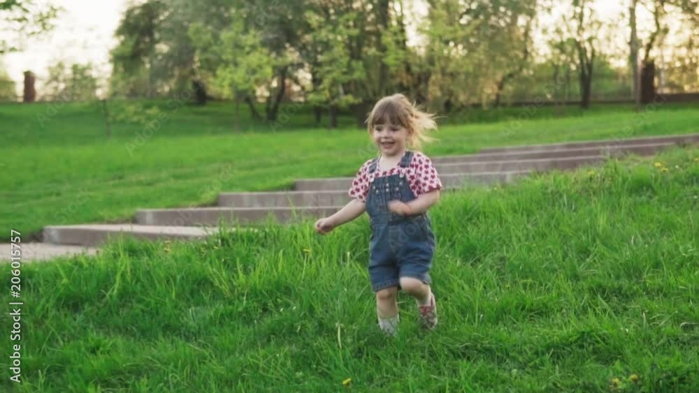 Happy little girl running on grass in sunny summer park Happy little girl running on grass in sunny summer park