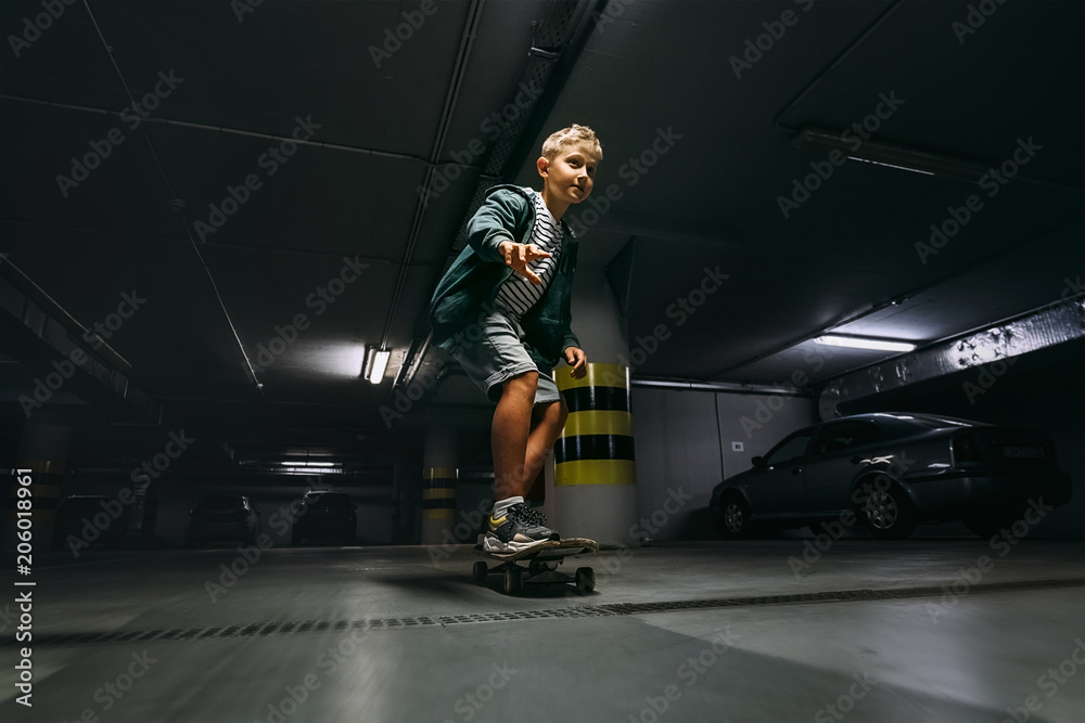 Boy skates on skateboard in undeground parking
