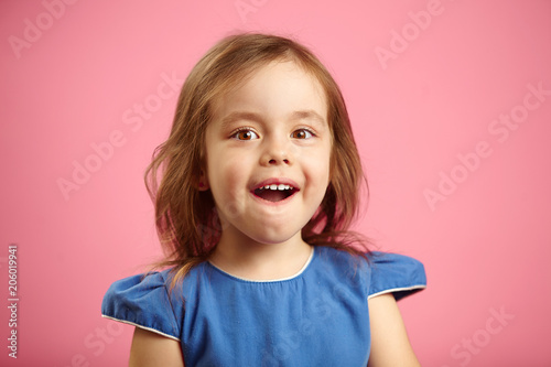 Isolated portrait of surprised girl three years old on pink isolated background. Small child expresses sincere emotions of astonishment and amazement, opens his mouth.
