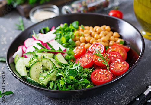 Salad of chickpeas, tomatoes, cucumbers, radish and greens. Dietary food. Buddha bowl. Vegan salad.