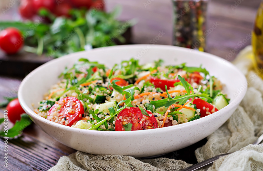 Salads with quinoa, arugula, radish, tomatoes and cucumber in bowl on wooden background. Healthy food, diet, detox and vegetarian concept. Salads with quinoa, arugula, radish, tomatoes and cucumber in bowl on wooden background. Healthy food, diet, detox and vegetarian concept.