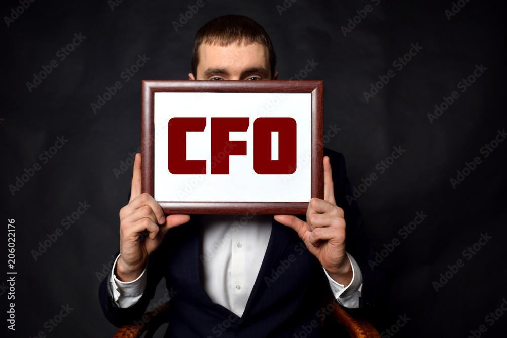 In the hands of a businessman a frame with the inscription:CFO In the hands of a businessman a frame with the inscription:CFO