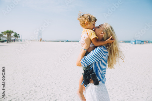 Photography Young mother and happy little son at sandy beach in Dubai, UAE
