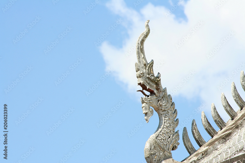 Traditional  Silver naga head sculpture on clear blue sky background