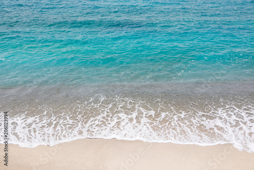 Top view of a beach, blue ocean waves, sand and water