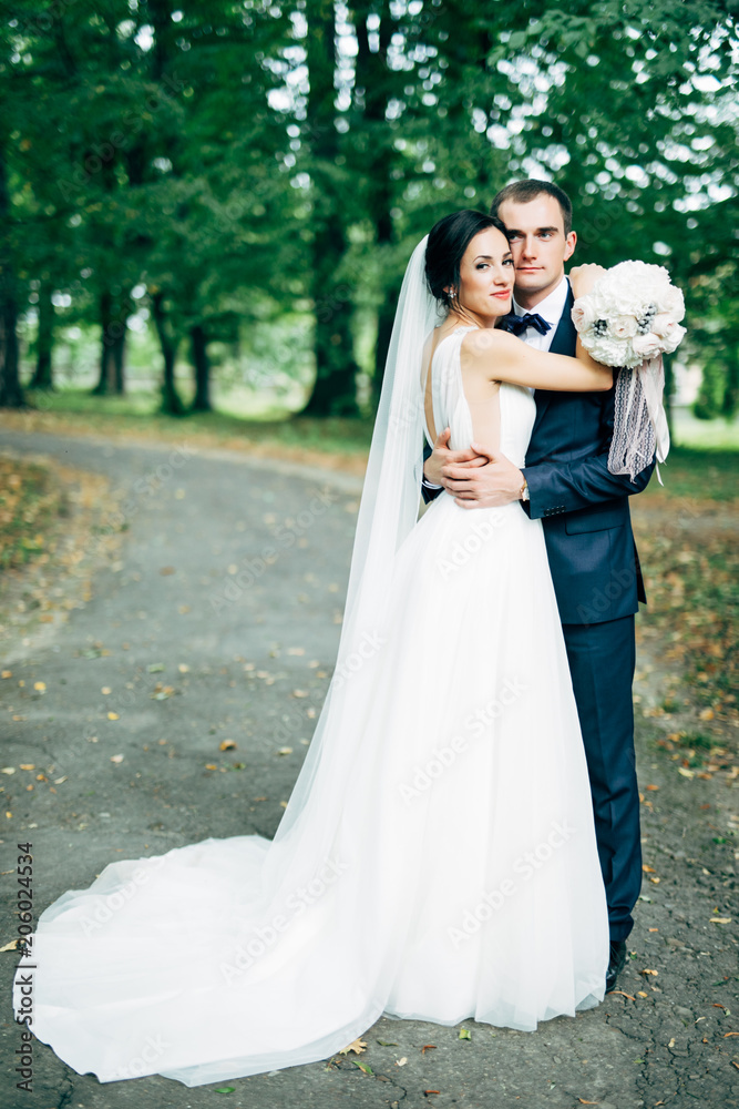 Bride and groom in a morning light in park. Wedding day Bride and groom in a morning light in park. Wedding day
