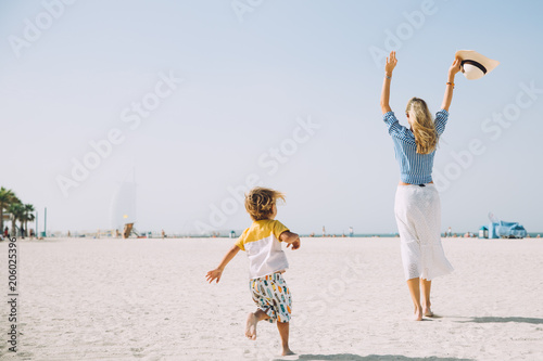 Photography Young mother and happy little son at sandy beach in Dubai, UAE