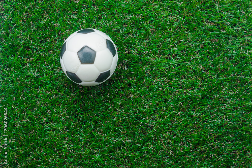 Table top view aerial image soccer or football season background.Flat lay object ball on the artificial green grass wallpaper.Free space for creative design mock up text and wording or content.