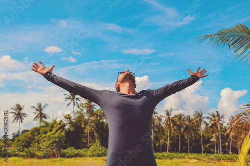 Man enjoying tropical climate with arms wide open.