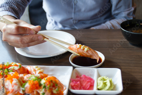People use chopsticks to pick up sushi.
