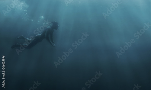 Male freediver snorkeling in deep sea. photo