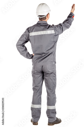 Full length portrait of a male builder in a helmet looking at camera over white wall background. repair, construction, building, people and maintenance concept.