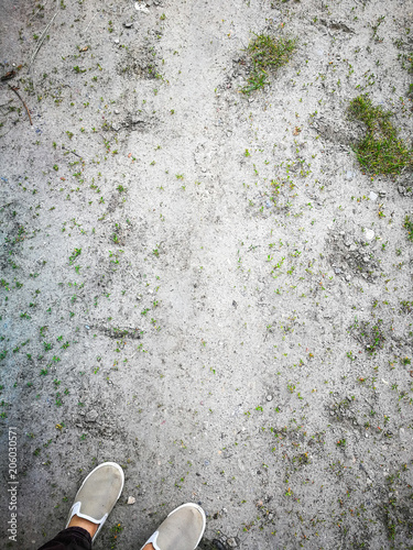 Top view of feet on dirt road