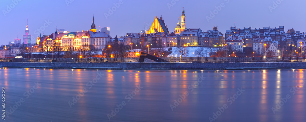 Panoramic view of Old Town with reflection in the Vistula River during evening blue hour, Warsaw, Poland.