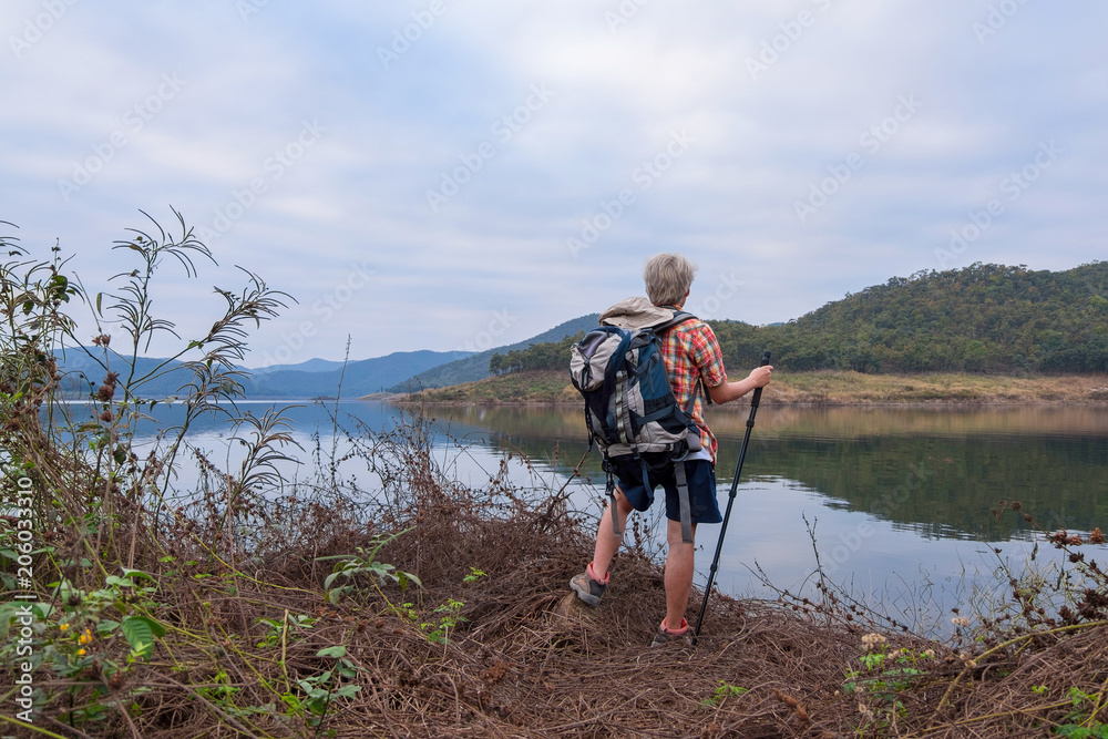 Young man trekker enjoy traveling with backpack, hiking concept, travel concept