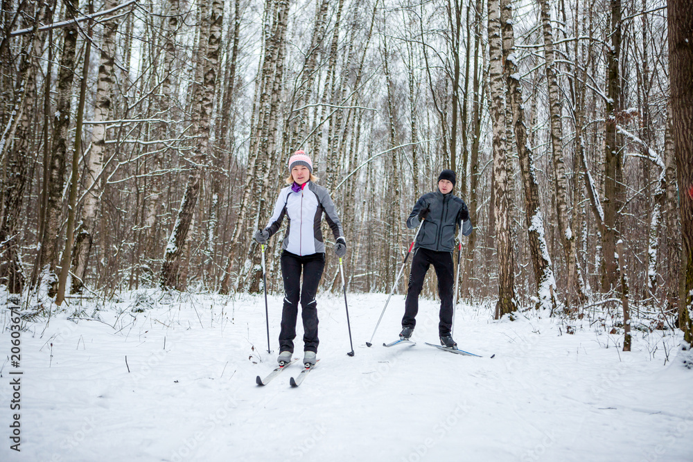 Image of sports woman and man skiing in winter forest
