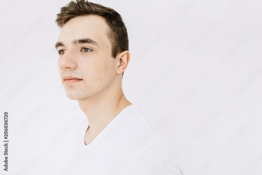 Portrait of a white young guy in a white t-shirt, isolated on a white background. Portrait of a white young guy in a white t-shirt, isolated on a white background.