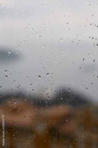 View of the sea and the city through a wet glass. Raindrops.
