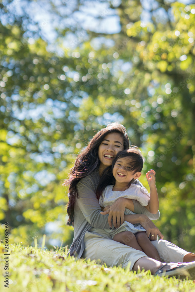 happy young daughter with mom in the park happy young daughter with mom in the park