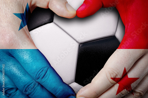 Hands painted with a Panama flag forming a heart over soccer ball background