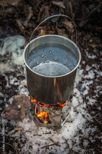 Water boiling in a camping pot on a folding hiking stove