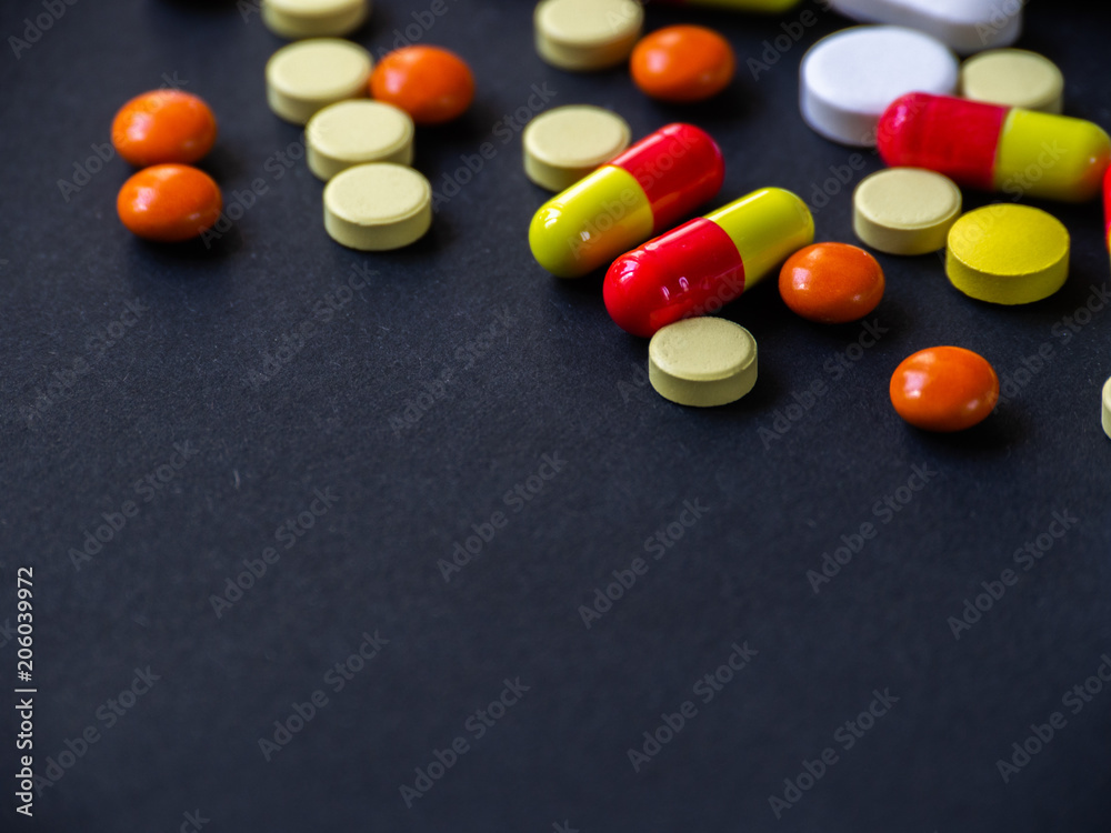 The pills are scattered on a black background. Tablets are scattered. Placebo.