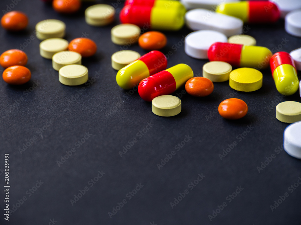 The pills are scattered on a black background. Tablets are scattered. Placebo.