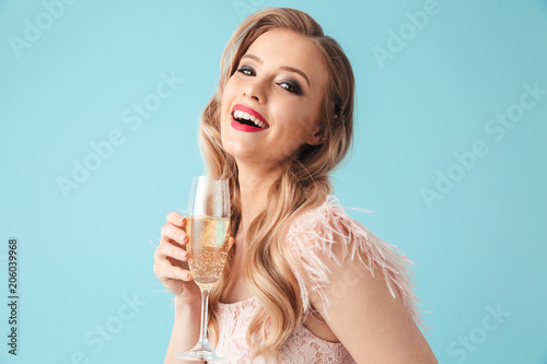 Side view of Cheerful woman in dress posing with champagne