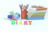word diary on blurred background of school supplies .photo with copy space