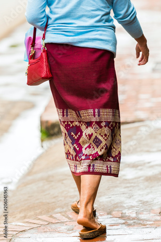 Woman in a skirt on a city street, Luang Prabang, Laos. Close-up. Vertical.