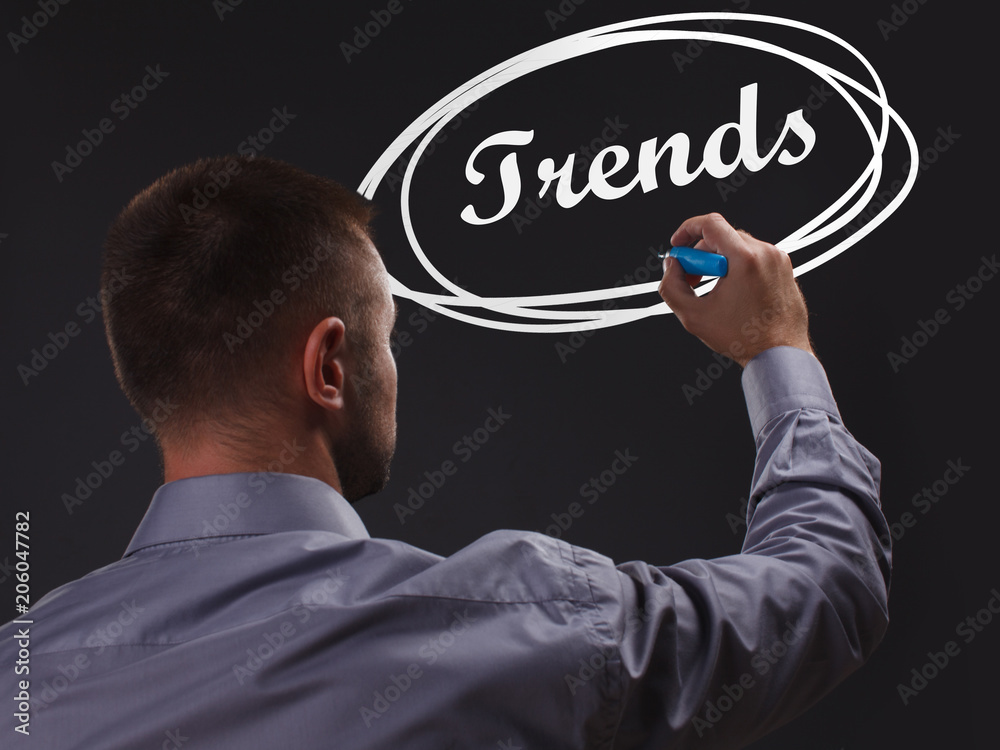 The concept of business, technology, the Internet and the network. Young businessman showing inscription: Trends The concept of business, technology, the Internet and the network. Young businessman showing inscription: Trends