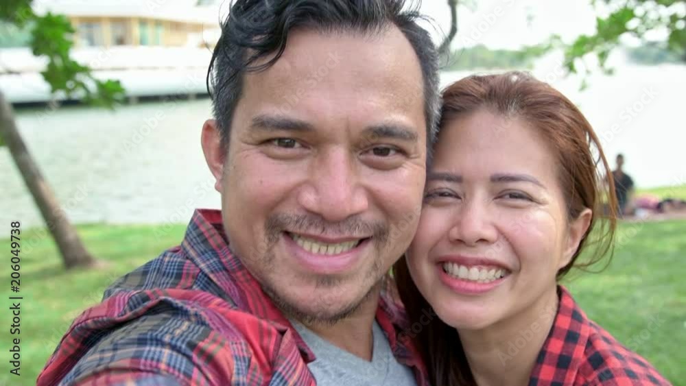 Slow motion of sweet couple hugging in park. Young Asian man and woman hugging each other in park. POV style Slow motion of sweet couple hugging in park. Young Asian man and woman hugging each other in park. POV style