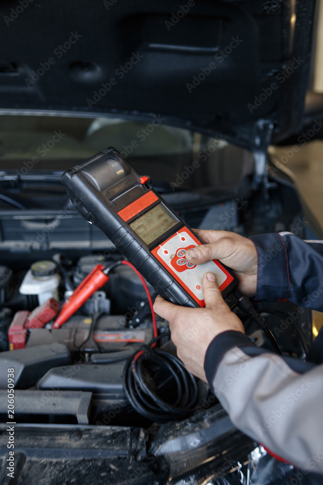 Accumulator charging. Hands and terminals. Car repair. Service