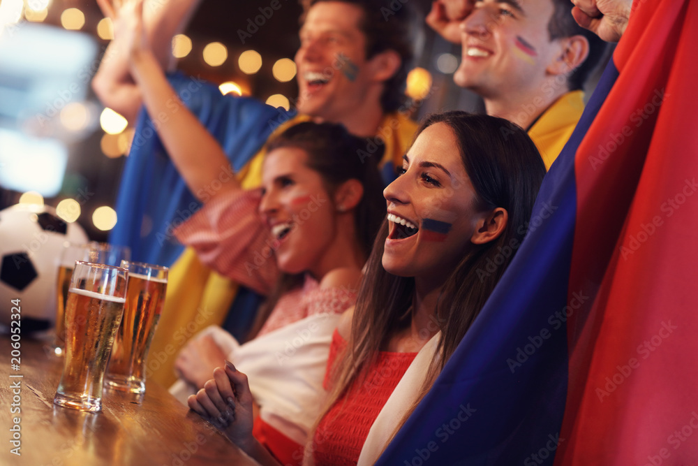 Group of friends watching soccer in pub