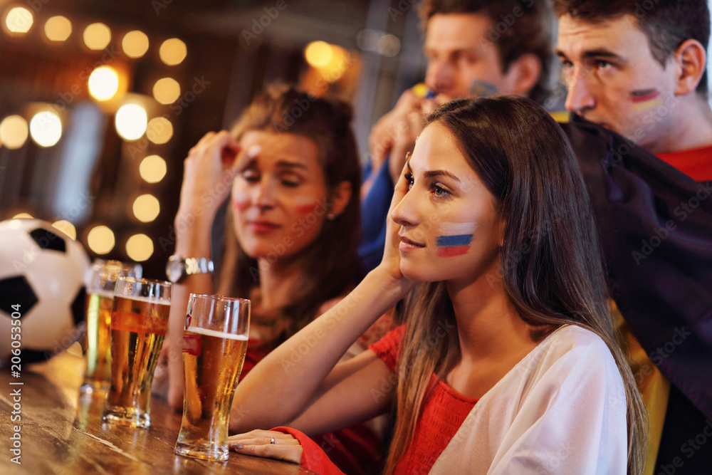 Group of friends watching soccer in pub