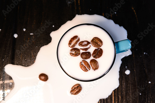 Coffee beans with milk splashes isolated on black background
