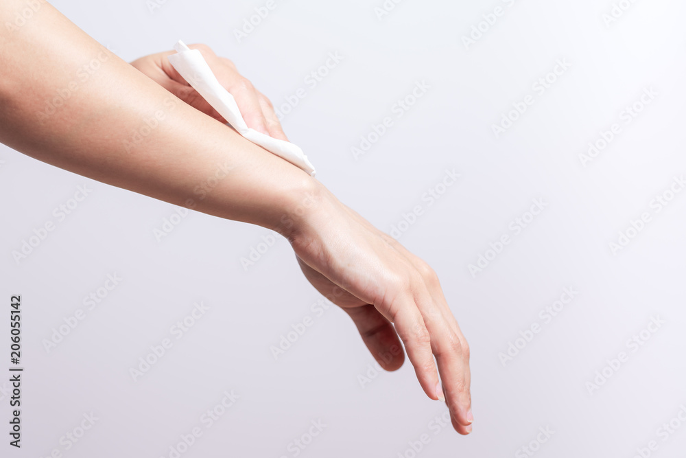 Woman cleaning her arm with white soft tissue paper. isolated on a white backgrounds