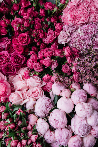 Fototapeta Naklejka Na Ścianę i Meble -  Beautiful fresh blossoming flowers texture at the florist shop in ombre color from magenta pink to pastel pink: ranunculus, peonies, roses, tulips, carnations, top view, flat lay 