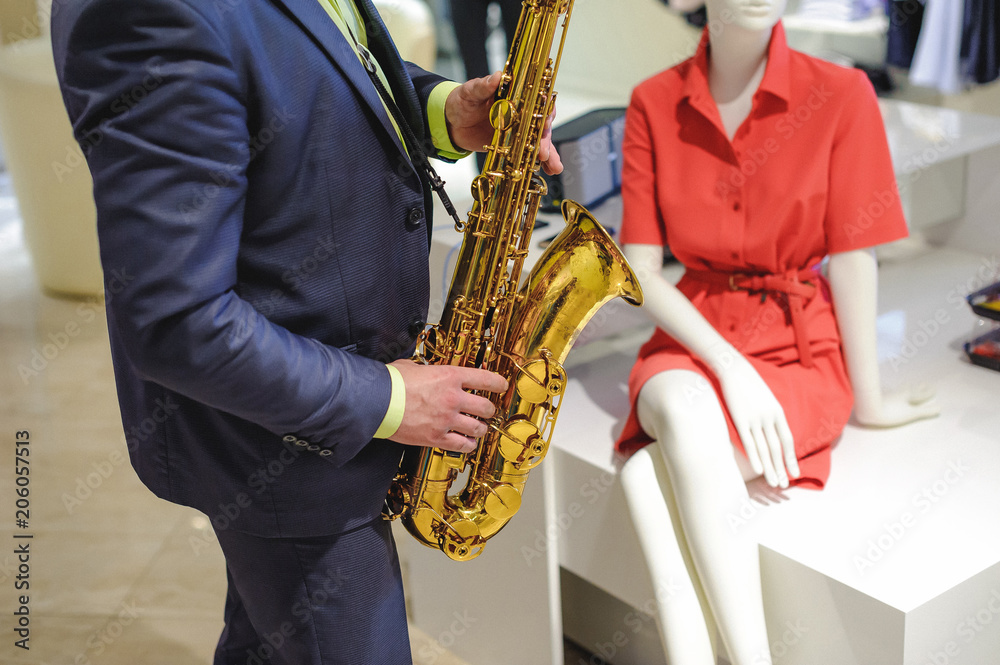 Naklejka premium musician plays the saxophone performance at a concert in shopping center of women's clothing store on holiday